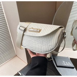 Detailed view of quilted faux leather texture with logo patch and wide strap buckle
