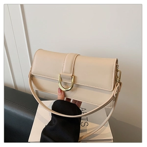Détail du sac à main beige en similicuir avec boucle en métal doré et texture mate élégante