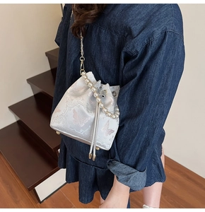 Vue détaillée du sac seau brodé avec poignée en perles et motifs de papillons