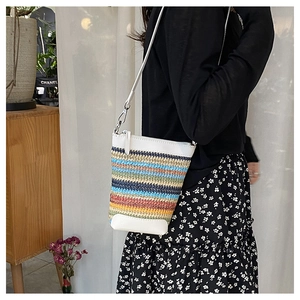 Detail of multi-color woven straw phone bag with white leather accents and silver hardware