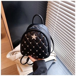 Detail of black quilted leather mini backpack with silver rivets and star emblem