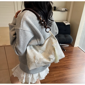 Détail du sac cabas en dentelle blanche avec papillons 3D et bandoulière en perles