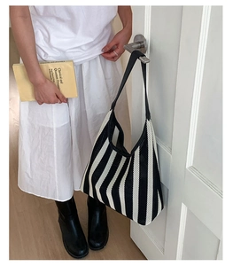 Detail of a large black and white striped woven tote bag with a soft knit texture