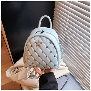 Close-up of quilted light blue mini backpack with silver rivets and rhinestone star detail
