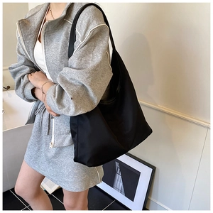 Minimalist large black hobo shoulder bag shown on model for a natural commute style