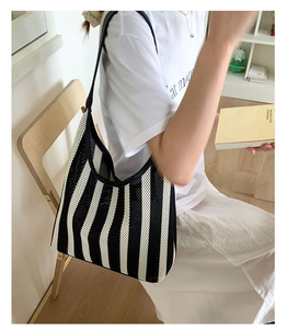 Detail of a large black and white striped tote bag with leather straps for daily use