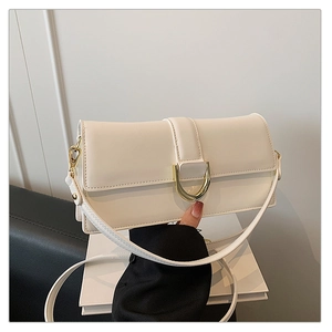 Détail du sac à bandoulière en cuir blanc avec boucle dorée en D et design à rabat élégant