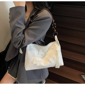 Texture de dentelle détaillée avec broderie papillon 3D et poignée en bois sur le sac cabas