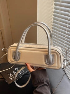 Minimalist cream leather baguette bag with silver trim and metallic top handle