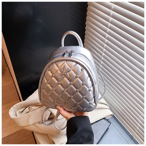 Detailed view of silver quilted backpack with star rhinestone and metallic finish
