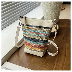 Close-up of a colorful woven crossbody phone bag with white leather trim and strap
