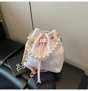 Broderie détaillée de fleurs et papillons sur sac seau rose avec poignée en perles