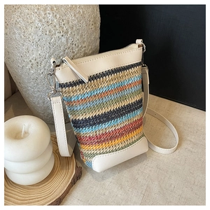 Detail of colorful striped straw mini crossbody bag with white leather trim and silver hardware