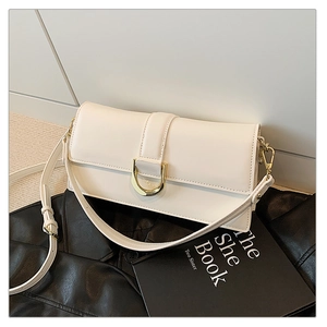 Détail du sac bandoulière en cuir blanc crème avec boucle en métal doré en forme de D