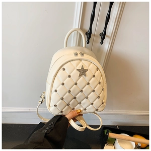 Close-up of white quilted leather mini backpack with silver rivets and star emblem