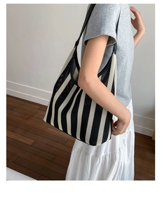 Close-up of black and white striped knit mesh tote bag with durable leather handle