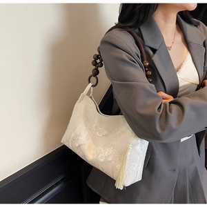 Détail du sac cabas blanc brodé de papillons avec anse perlée et glands crème