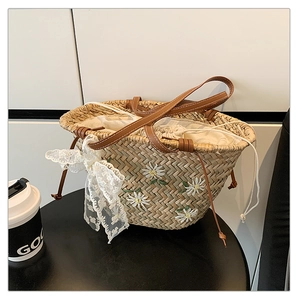 Detail of straw bucket bag with white daisy embroidery and lace bow decoration