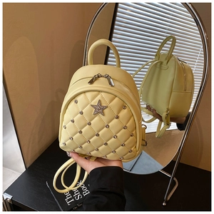 Macro view of lemon yellow quilted mini backpack with rhinestone star and metal studs