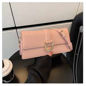 Détail du sac à bandoulière rose avec boucle en D dorée moderne sur cuir lisse