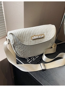 Minimalist cream white quilted crossbody saddle bag with adjustable wide strap and logo detail