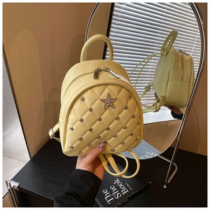 Detailed shot of yellow quilted leather mini backpack with rhinestone star and metal studs