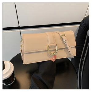 Détail du sac à bandoulière en cuir crème avec boucle dorée en forme de fer à cheval