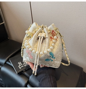 Détails de broderie chinoise sur sac seau crème avec carpe koi et poignée en perles