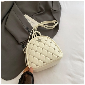 Close-up of white quilted mini backpack with sparkling rhinestones and a star metal buckle