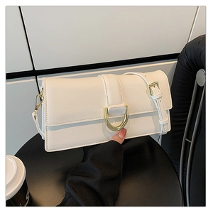 Détails de ce sac à bandoulière blanc avec une boucle en D métallique dorée élégante
