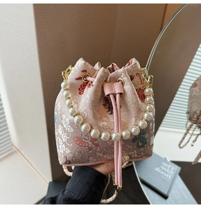 Détail du sac seau rose brodé avec poignée en perles et motifs floraux traditionnels