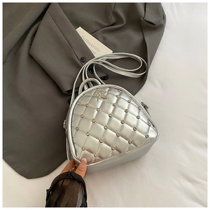 Detailed view of silver quilted backpack featuring rhinestone studs and star ornament