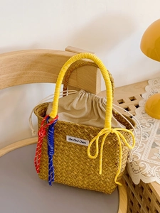 Handmade straw bucket bag with yellow bow handle and drawstring inner for summer beach vacation