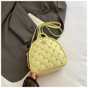 Detail of light yellow quilted mini backpack featuring star-shaped rhinestone embellishments