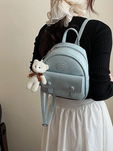 Vintage light blue mini backpack with pebbled leather texture and plush bear charm