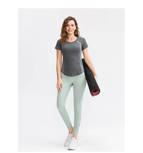 Détail de l'ensemble de yoga extensible avec t-shirt gris et leggings verts respirants