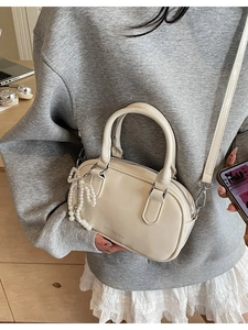 Off-white oil wax leather Boston bag with pearl bow pendant and detachable strap