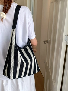 Black and white striped knit tote bag with black leather straps for summer beach vacation
