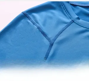 Detail view of reinforced flatlock stitching on the shoulder of blue athletic compression shirt