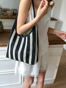 Minimalist black and white striped woven tote bag with leather straps for beach holidays