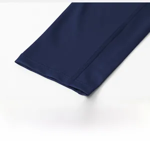 Macro shot of reinforced four-needle six-thread stitching on dark blue sports leggings