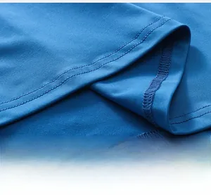Detailed close-up of double-stitched hem and knit fabric on men's blue compression shirt