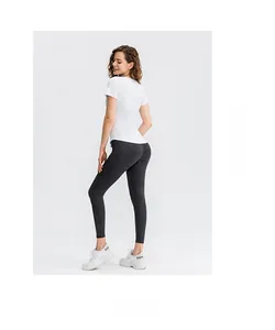 Vue arrière d'une femme en t-shirt de yoga blanc et legging gris marbré
