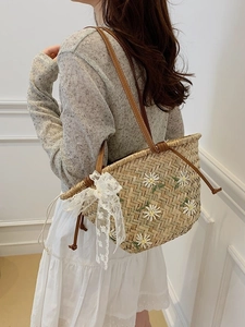 Straw bucket bag with daisy embroidery, lace bow, and leather strap for summer beach vacation