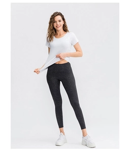 Détail d'un t-shirt de sport blanc extensible et d'un legging de yoga motif marbre