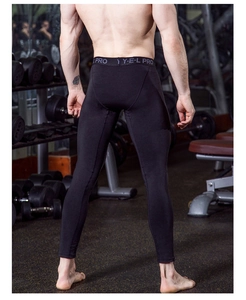 Men's compression pants with elastic waistband shown from the back in a gym setting