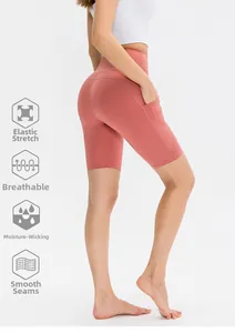 Dettaglio degli shorts da yoga a vita alta rosa pesca con tasche laterali ed effetto push-up