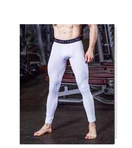 Close-up of men's white compression pants with black elastic waistband in a gym setting
