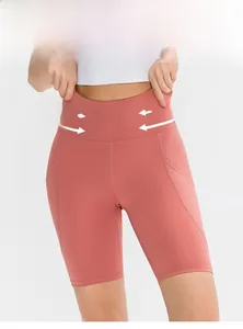 Dettaglio dei pantaloncini yoga rosa corallo a vita alta con cuciture e tessuto elastico