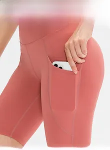 Dettaglio dei pantaloncini da yoga corallo a vita alta con tasca laterale per lo smartphone